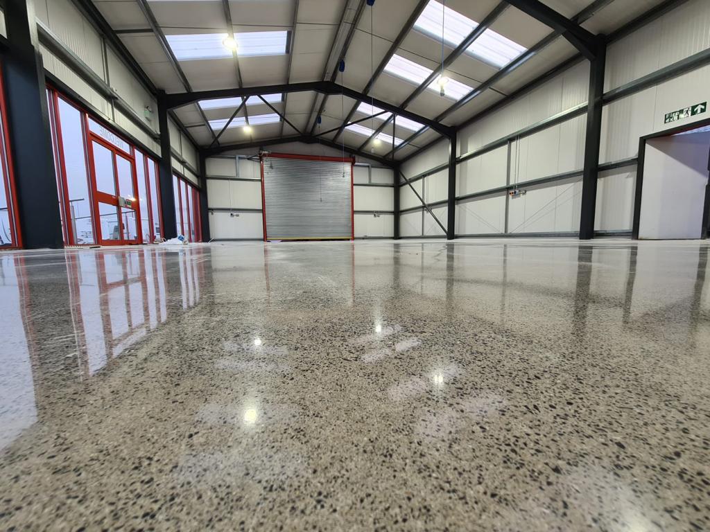 A bright, reflective polished concrete flooring in a warehouse