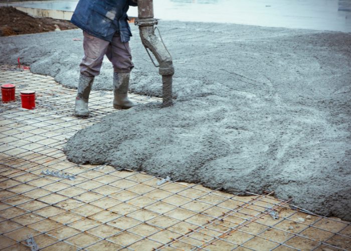 pouring concrete into a reinforced base to act as flooring for a warehouse
